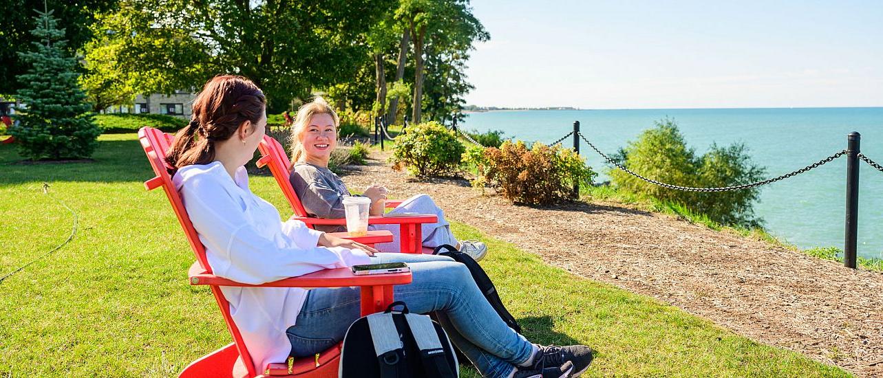 Students sitting on red chair facing Lake Michigan.